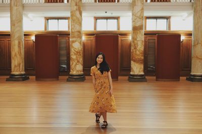 Portrait of smiling woman standing on hardwood floor