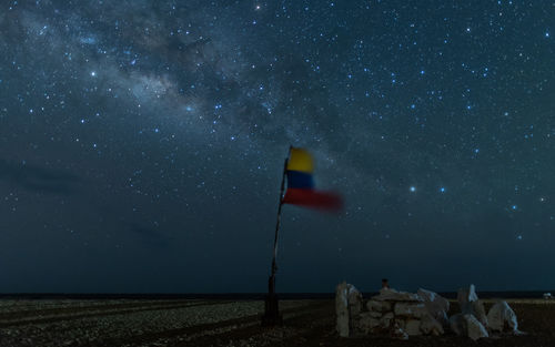 Scenic view of colombian flag on field against sky at night