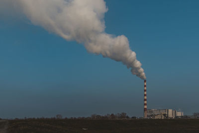 Smoke emitting from chimney against sky