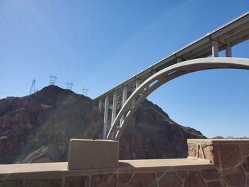 Bridge over mountain against blue sky