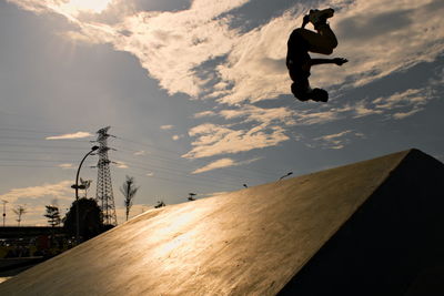 Low angle view of silhouette man skateboarding against sky during sunset