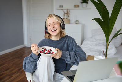 Portrait of young woman sitting on sofa at home