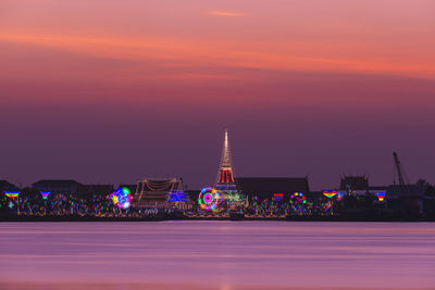 Illuminated buildings against sky during sunset