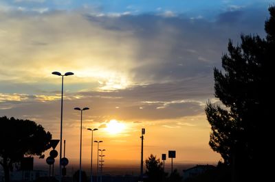 Low angle view of silhouette street against sky at sunset