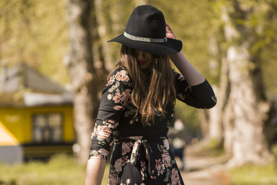 Woman wearing hat standing in park