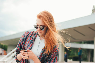 Young woman using mobile phone outdoors