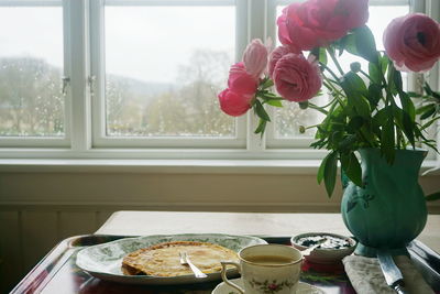 Close-up of roses in vase on table at home