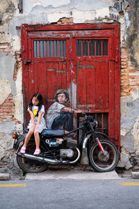 Full length of woman sitting on bicycle in city