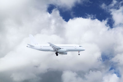 Low angle view of airplane flying against sky