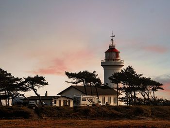 Lighthouse by sea against sky