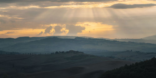 Sunrise and god rays in tuscan countryside