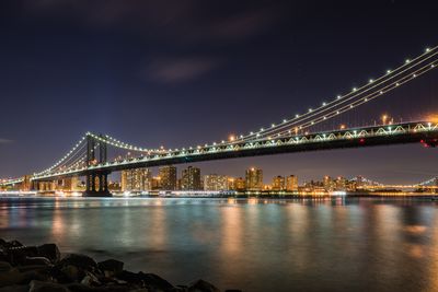 Suspension bridge over river at night