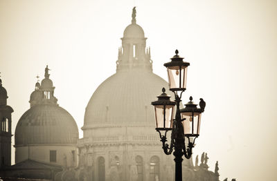 Low angle view of santa maria della salute and street light against clear sky