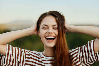 Portrait of young woman against sky