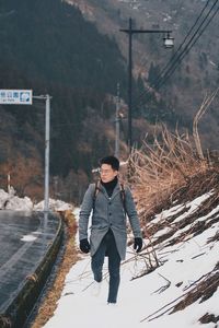 Man walking on snow covered footpath