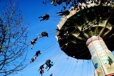 Low angle view of ferris wheel against blue sky