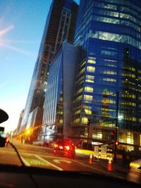 Illuminated city street against sky at night