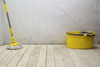 Yellow umbrella on footpath against wall