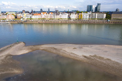 River by buildings against sky in city