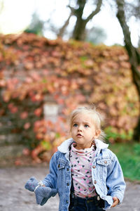 Portrait of girl standing against trees