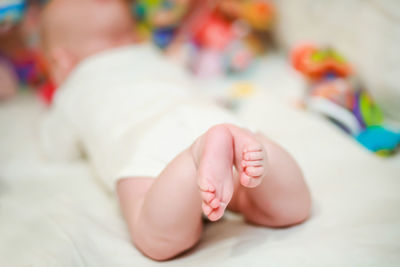 Close-up of baby boy lying on bed at home