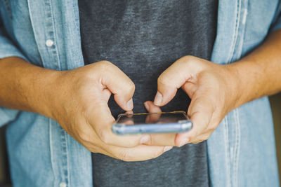 Close up a man holding texting message chatting with friend with mobile phone