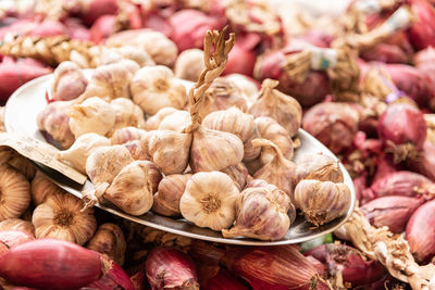 Close-up of garlic and onions for sale in market