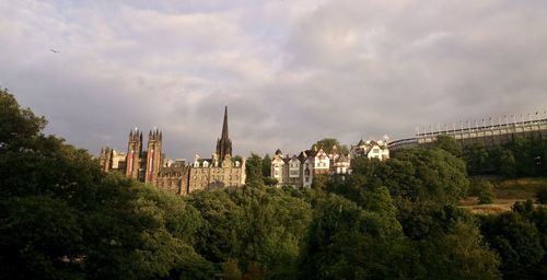 Panoramic view of buildings and trees against sky