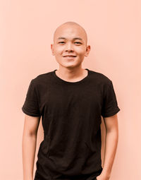 Portrait of teenage girl standing against wall