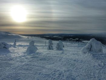 Sun shining over snow covered landscape
