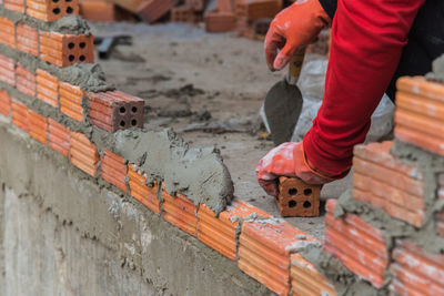 Construction worker making brick wall at construction site