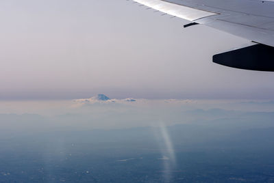 Airplane flying over sea against sky