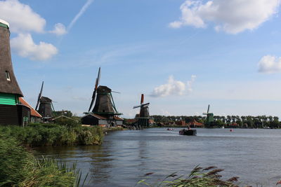 River amidst windmills against sky