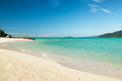 Scenic view of beach against blue sky