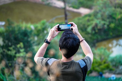 Rear view of man photographing