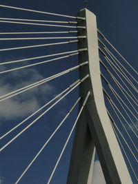 Low angle view of suspension bridge against sky