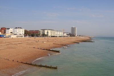 Sea by buildings against sky in city