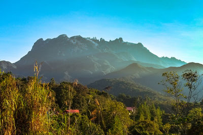 Scenic view of mountains against blue sky