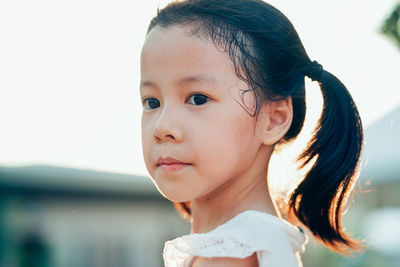 Close-up portrait of cute girl looking away