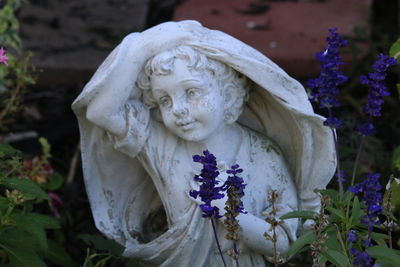 Close-up of angel statue against white wall