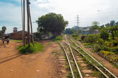 Railroad tracks amidst trees against sky