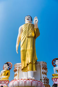 Low angle view of statue against blue sky