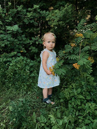 Girl standing against plants