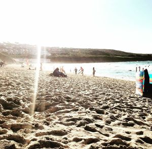 People at beach against clear sky