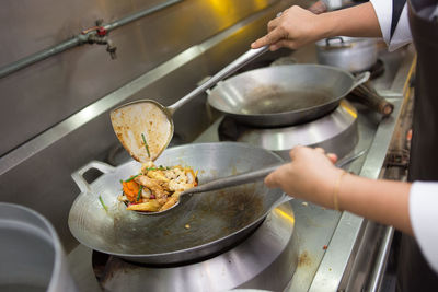 Cropped image of female chef preparing food in kitchen