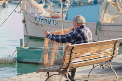 Man sitting on bench in boat