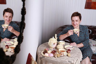 Portrait of smiling woman drinking coffee at home