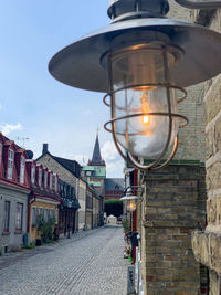 Street light on footpath amidst buildings in city