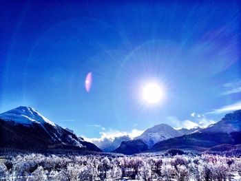 Scenic view of snowcapped mountains against blue sky