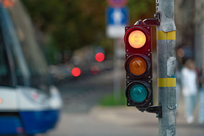 Blurred view of city traffic with traffic lights, in the foreground a semaphore with a red light